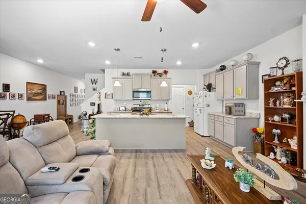 a living room with lots of furniture and kitchen view