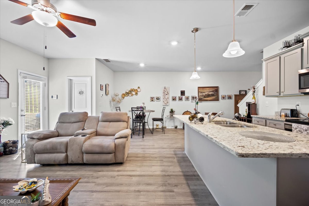 7503 Knoll Hollow Road Lithonia, GA 30058 - Photo 13 of 34 a living room with furniture kitchen view and a wooden floor