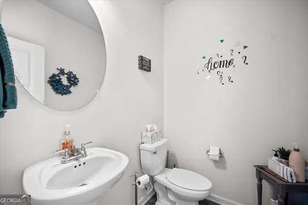 a bathroom with a sink mirror and toilet