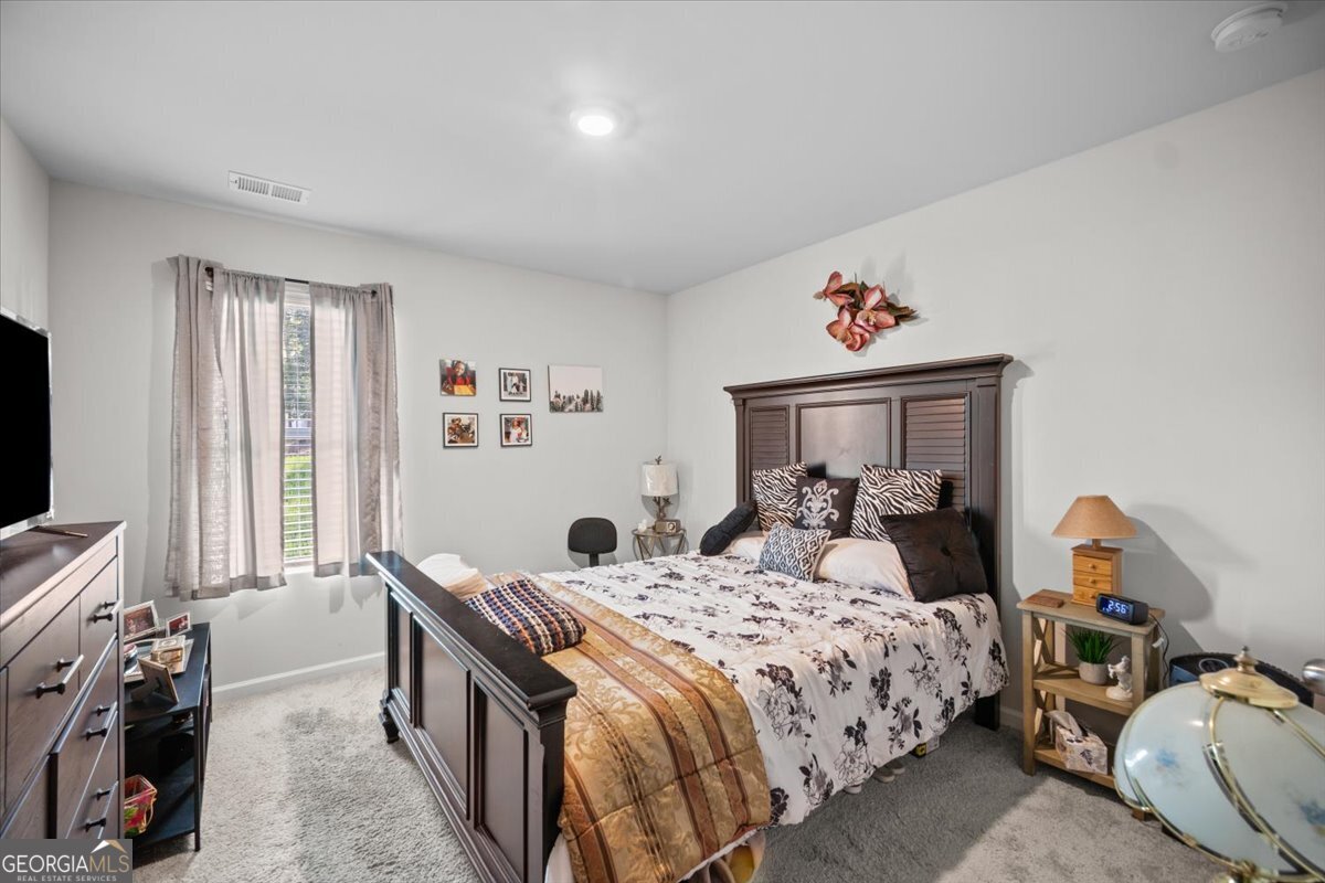 7503 Knoll Hollow Road Lithonia, GA 30058 - Photo 18 of 34 a bedroom with a bed and a flat screen tv