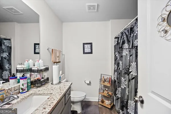 a bathroom with a sink toilet and shower curtain
