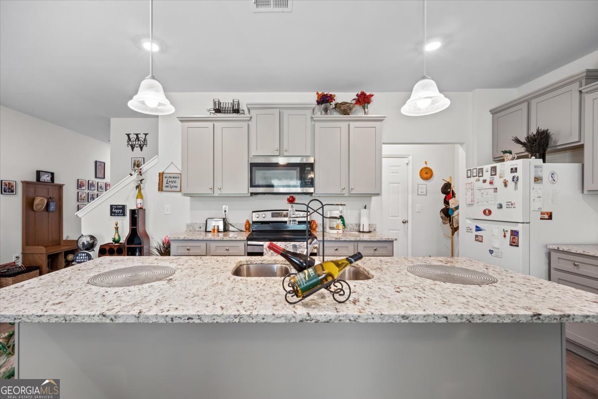 7503 Knoll Hollow Road Lithonia, GA 30058 - Photo 8 of 34 a kitchen with stainless steel appliances granite countertop a sink refrigerator and microwave