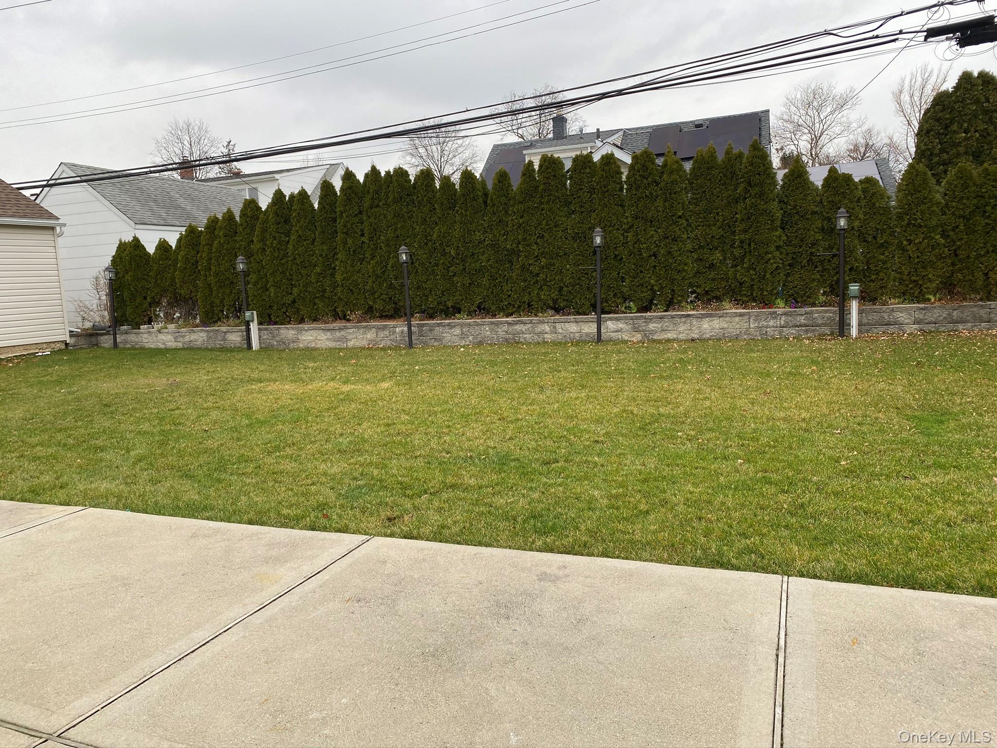25 Woodhollow Road Albertson, NY 11507 - Photo 12 of 15 a view of a swimming pool with a lawn chairs under an umbrella