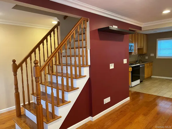 a view of a livingroom with wooden floor and stairs