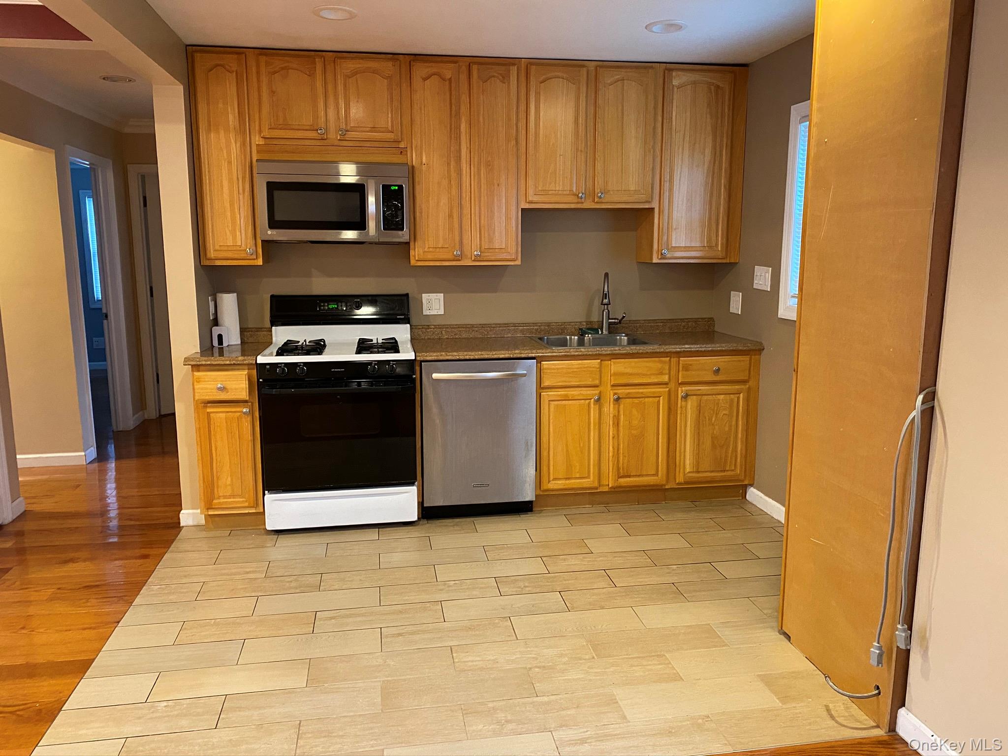25 Woodhollow Road Albertson, NY 11507 - Photo 7 of 15 a kitchen with stainless steel appliances granite countertop a stove a sink and a microwave