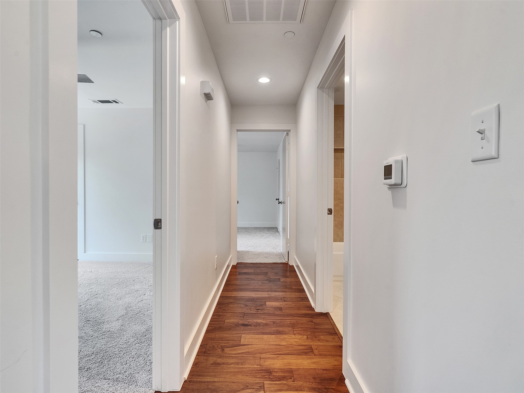 2829 Timmons Lane, Unit 204 Houston, TX 77027 - Photo 14 of 32 a view of a hallway with wooden floor and a bathroom