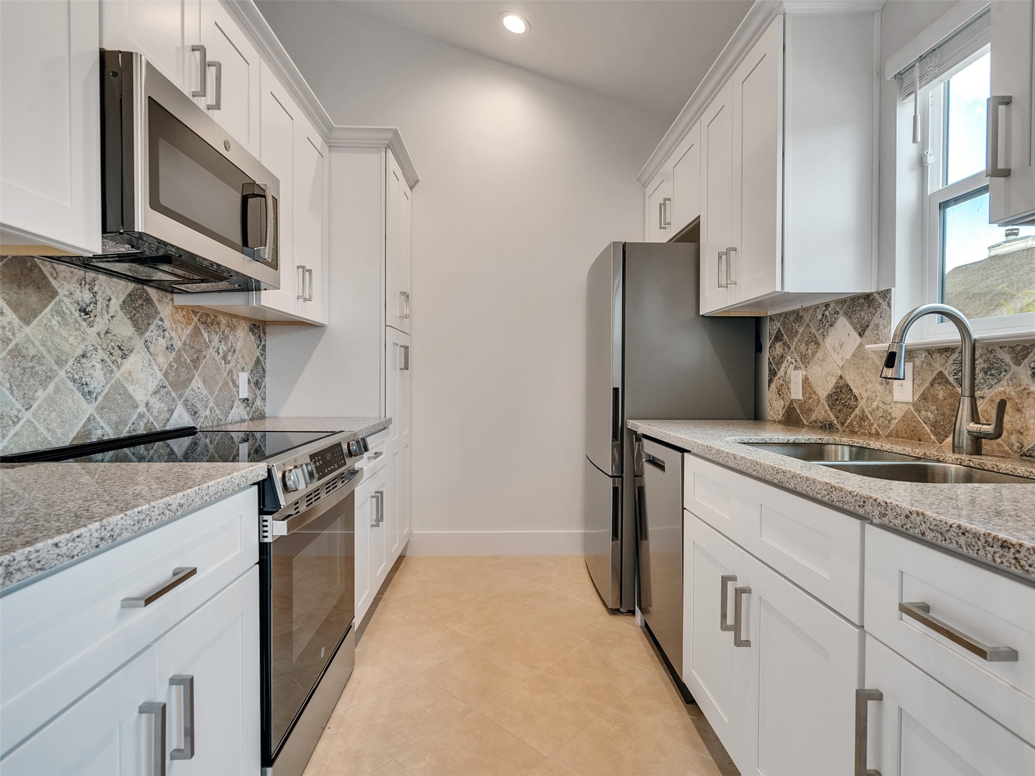 2829 Timmons Lane, Unit 204 Houston, TX 77027 - Photo 5 of 32 a kitchen with stainless steel appliances granite countertop a stove a sink and a microwave