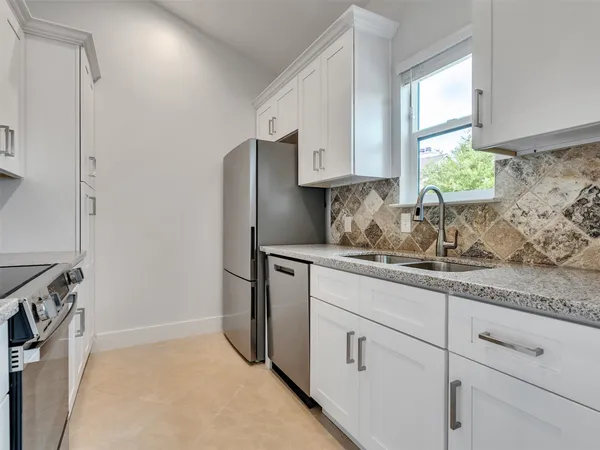a view of a kitchen with a stove wooden cabinet wooden floor chandelier and windows