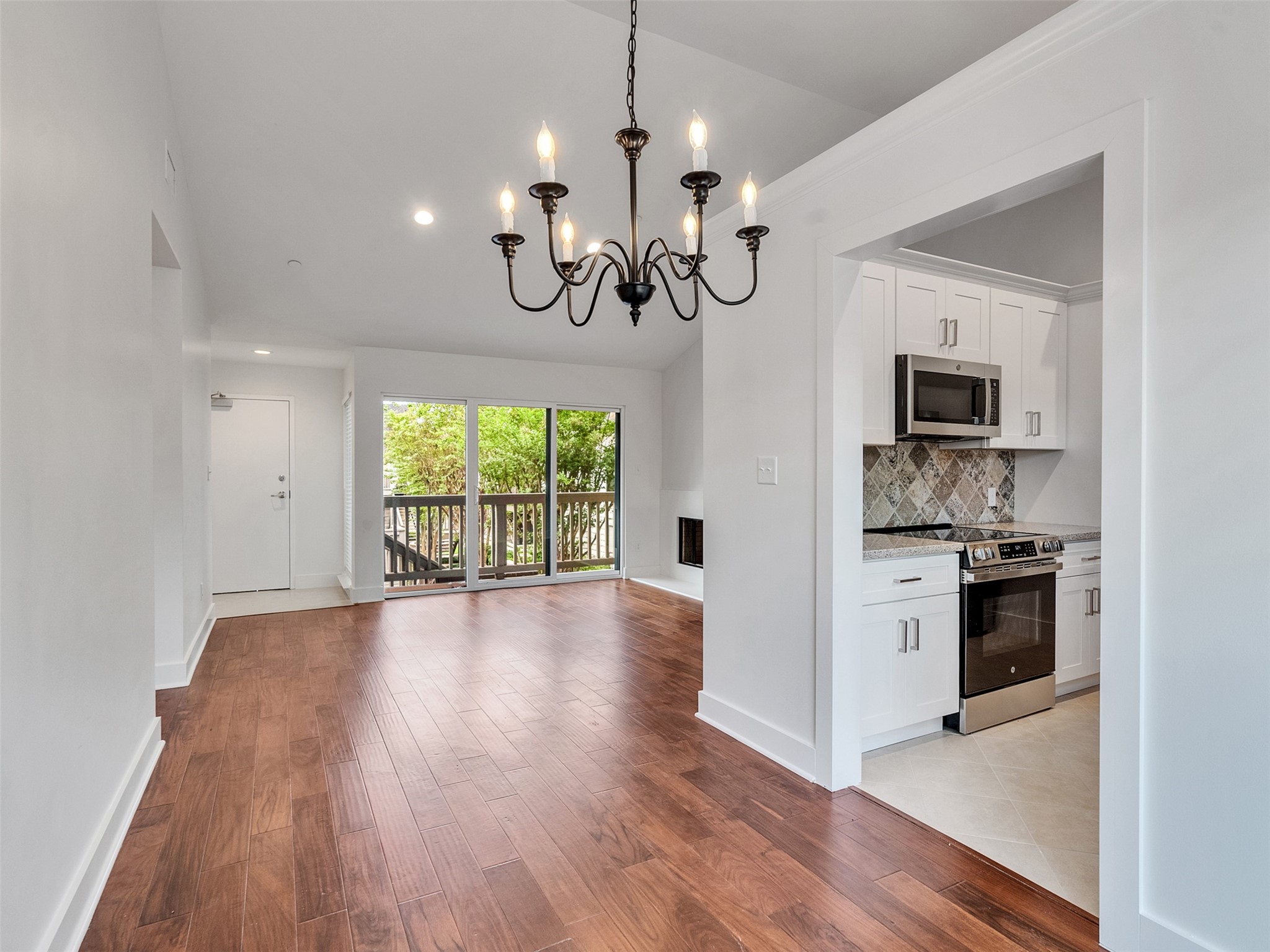 2829 Timmons Lane, Unit 204 Houston, TX 77027 - Photo 8 of 32 a view of a kitchen with a stove wooden cabinet wooden floor chandelier and windows