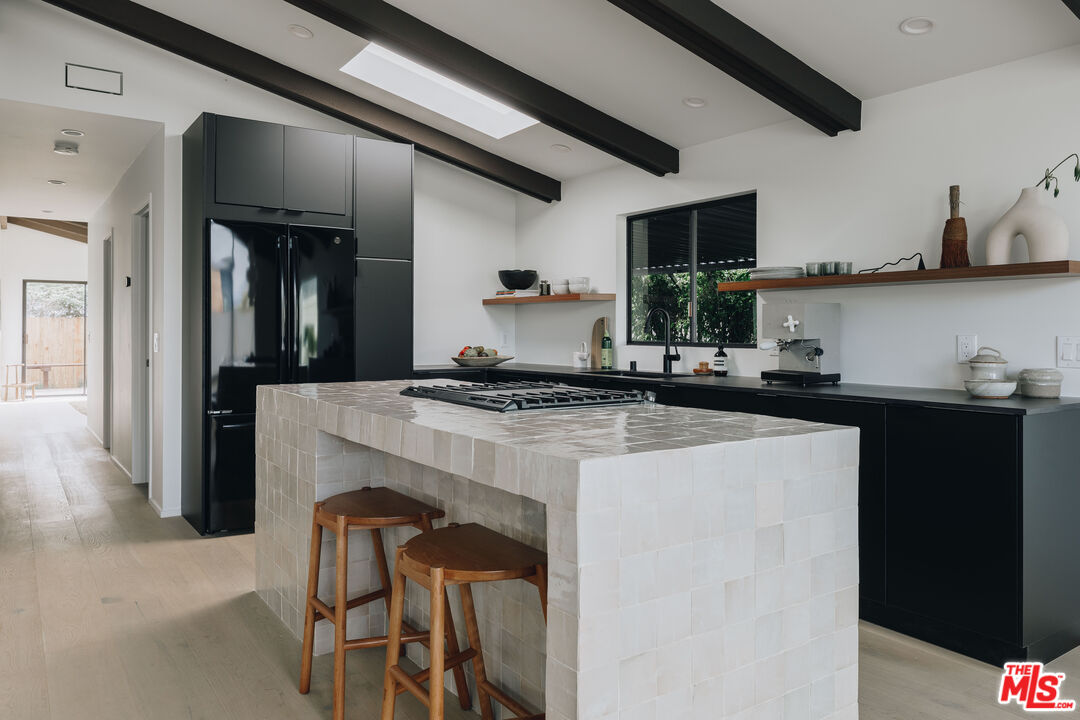 29500 Heathercliff Road, Unit 220 Malibu, CA 90265 - Photo 11 of 43 a kitchen with a refrigerator and cabinets