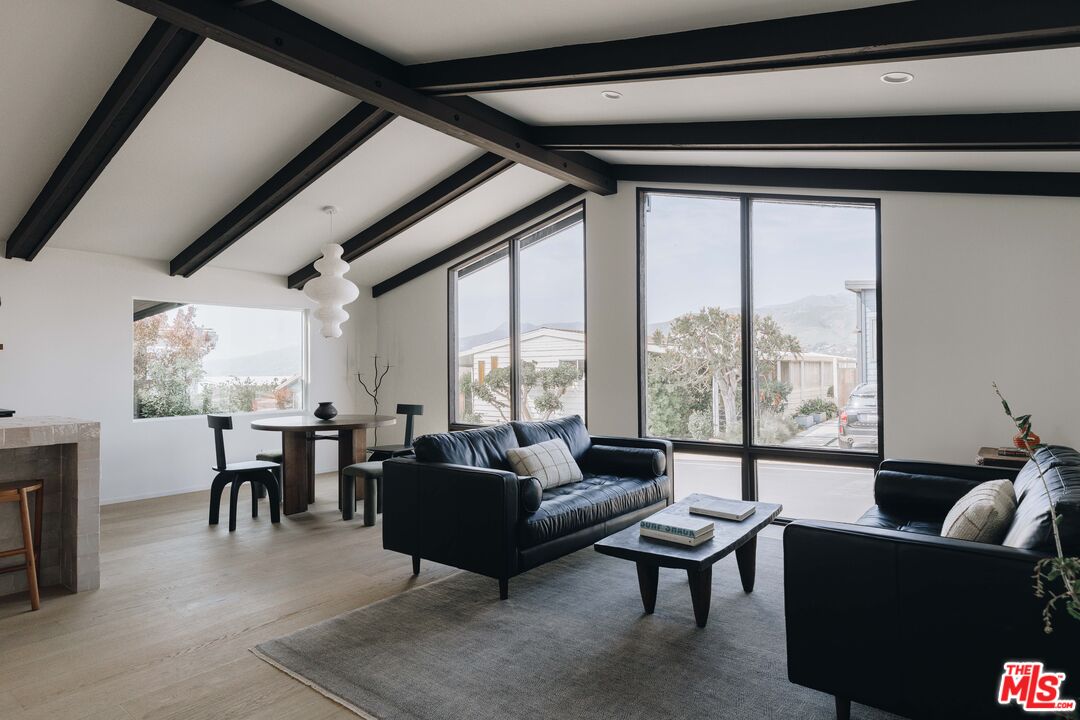 29500 Heathercliff Road, Unit 220 Malibu, CA 90265 - Photo 6 of 43 a living room with furniture large windows and a table