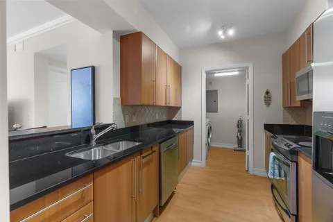 a kitchen with granite countertop a sink and cabinets