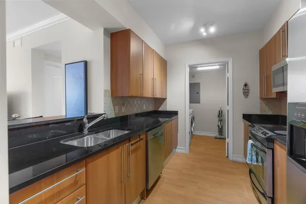 a kitchen with granite countertop a sink and cabinets