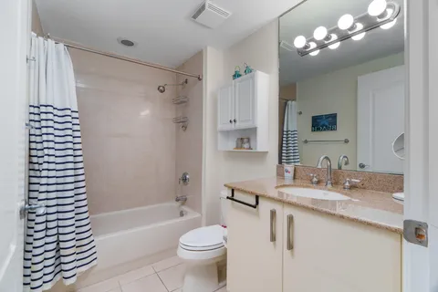 a bathroom with a bathtub a sink and a large mirror