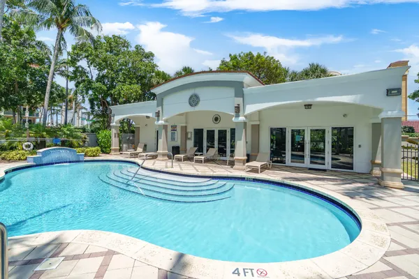 a view of a white house with swimming pool table and chairs