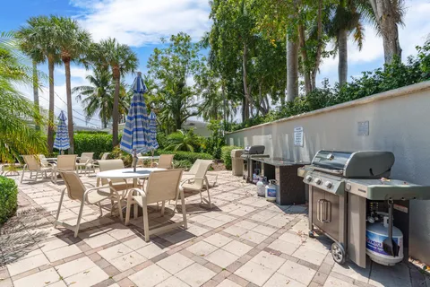 a view of a patio with a dining table and chairs with a fire pit and a large tree