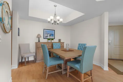 a view of a dining room with furniture a chandelier and wooden floor