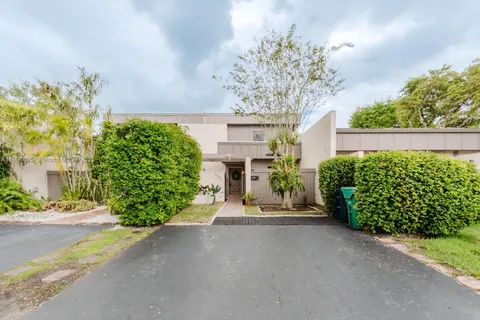 a view of a garden with a bench in front of a house