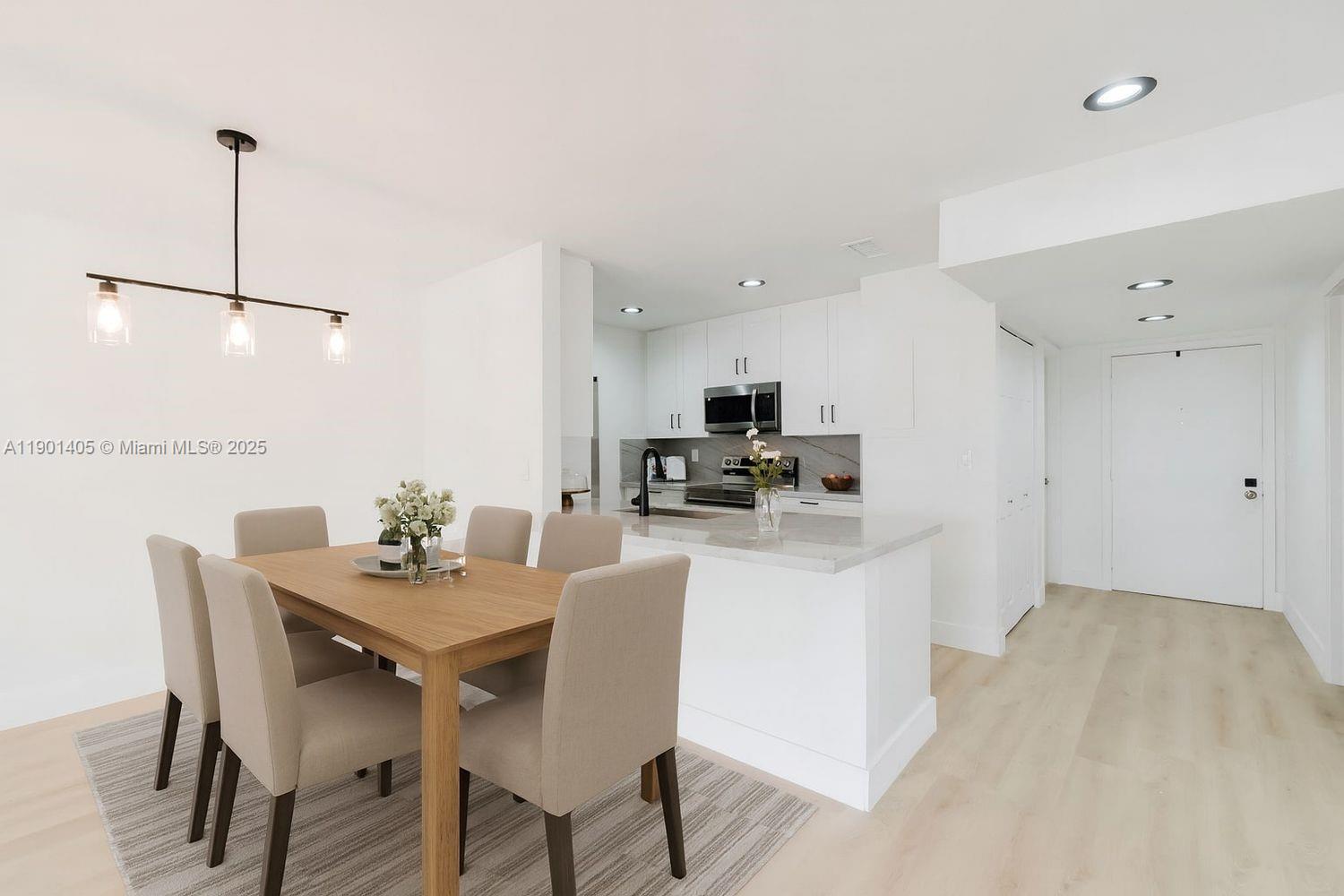 7354 Southwest 105th Place Miami, FL 33173 - Photo 2 of 15 a kitchen with stainless steel appliances kitchen island granite countertop a dining table chairs and a refrigerator