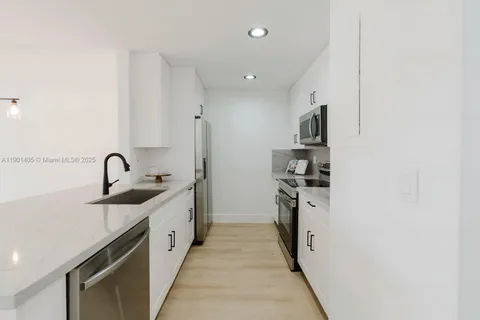 a kitchen with stainless steel appliances granite countertop a sink and a stove top oven with dishwasher