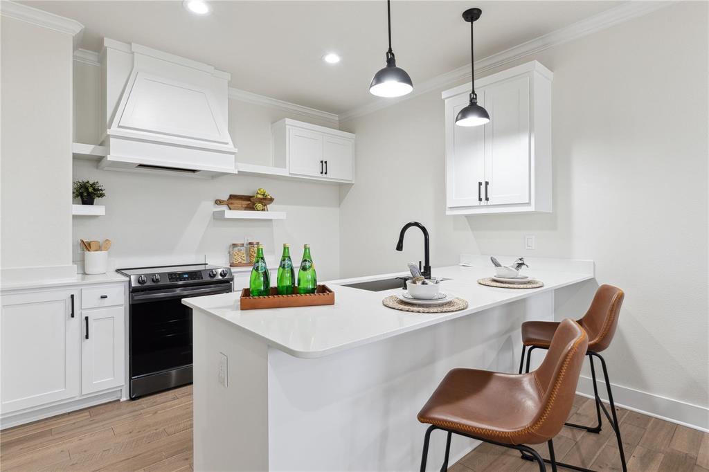 3230 Elihu Street, Unit 2 Dallas, TX 75210 - Photo 6 of 20 a kitchen with stainless steel appliances granite countertop a stove a sink a refrigerator a window and white cabinets with wooden floor