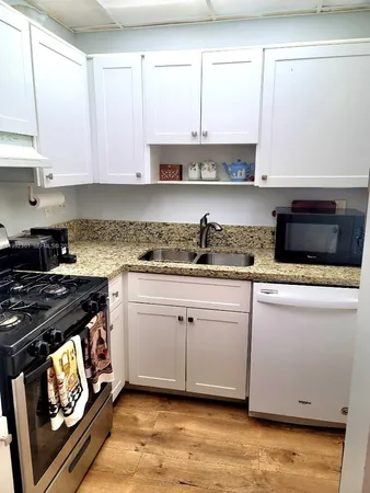a kitchen with stainless steel appliances granite countertop a stove a sink and a microwave