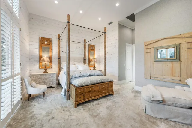 a spacious bedroom with a bed and glass window