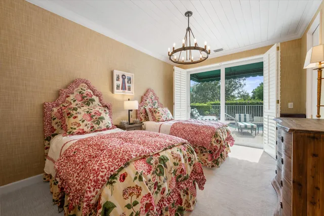 a bedroom with two large bed and a chandelier