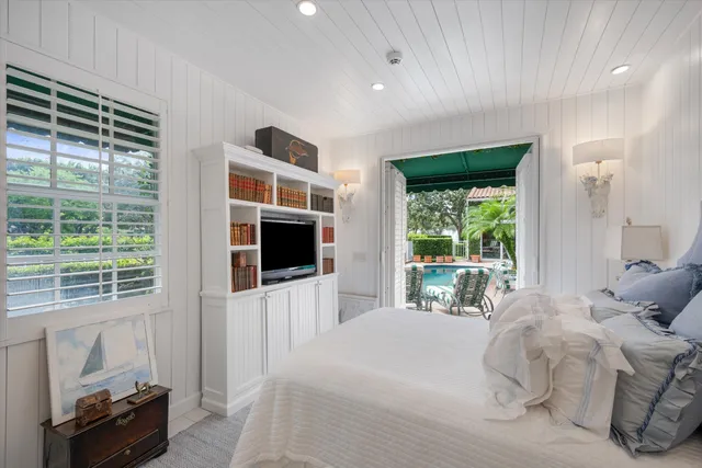 a bedroom with a large bed and a flat tv screen