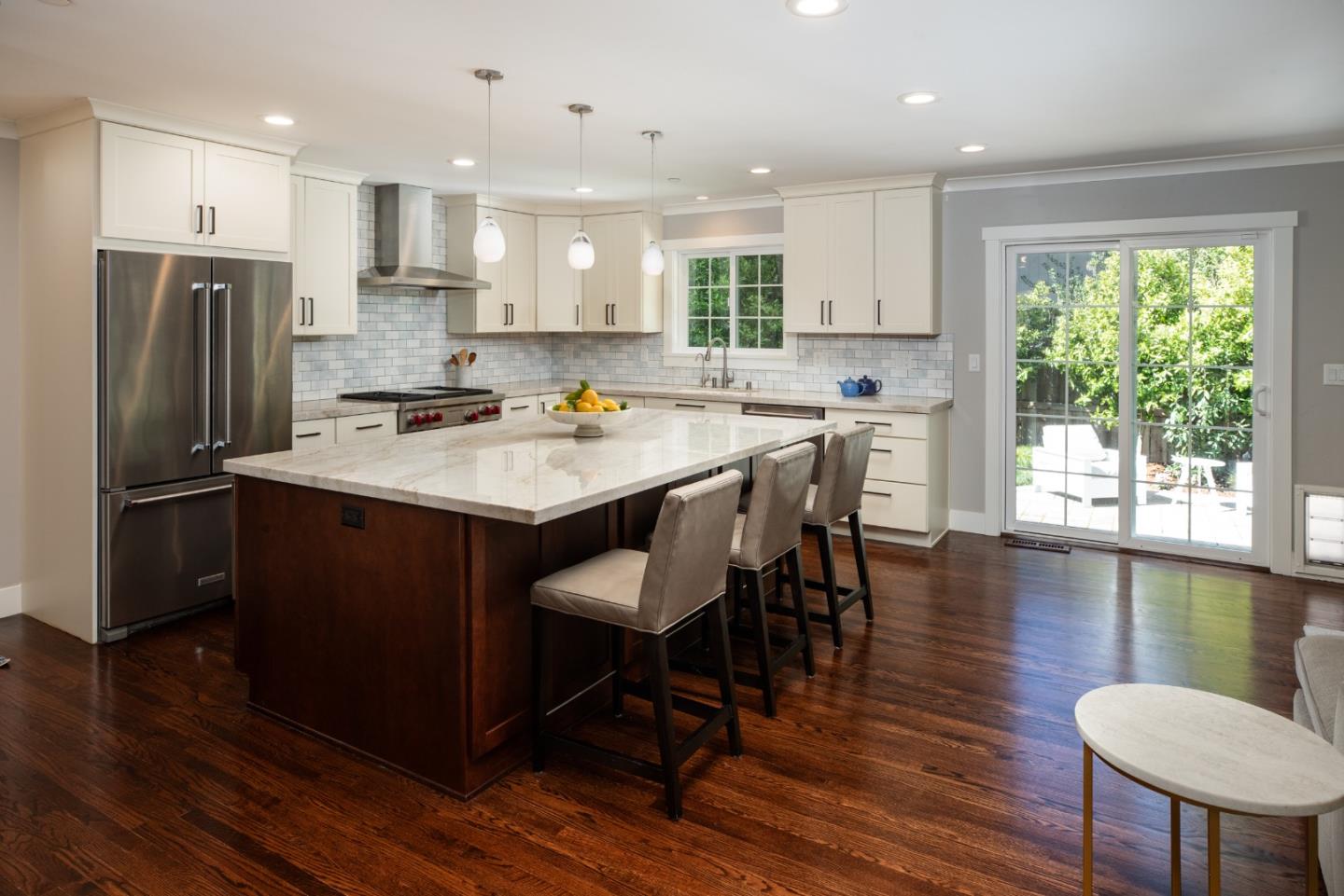 135 Emma Lane Menlo Park, CA 94025 - Photo 6 of 16 a kitchen with stainless steel appliances granite countertop a stove a refrigerator a sink a dining table and chairs with wooden floor