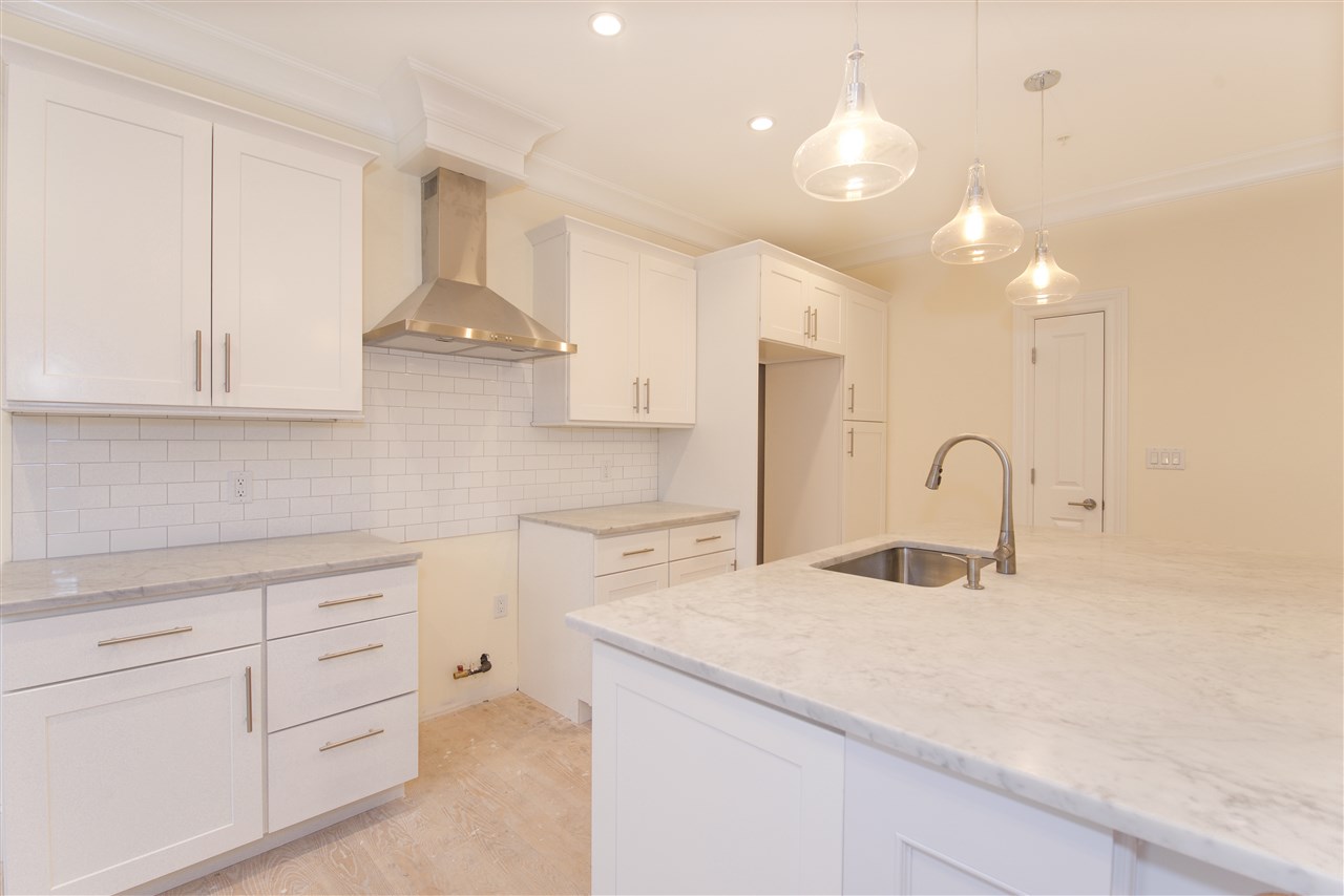 a kitchen with kitchen island a sink stainless steel appliances and cabinets