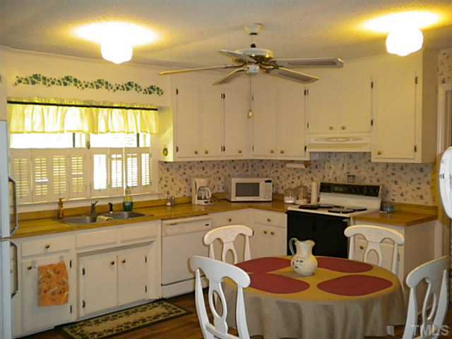 1024 Pagan Road Raleigh, NC 27603 - Photo 6 of 25 a kitchen that has a lot of cabinets in it and a window