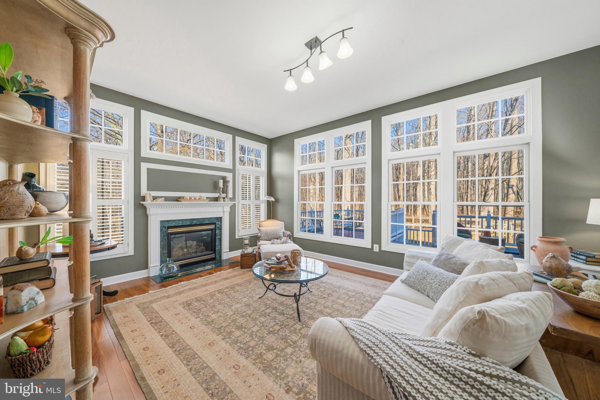 18700 Olney Mill Road Olney, MD 20832 - Photo 26 of 86 a living room with furniture a fireplace and a floor to ceiling window