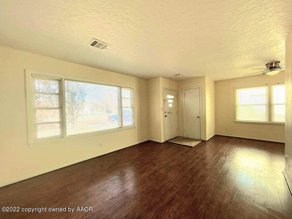 4319 Gables Street Amarillo, TX 79110 - Photo 3 of 15 an empty room with wooden floor and windows
