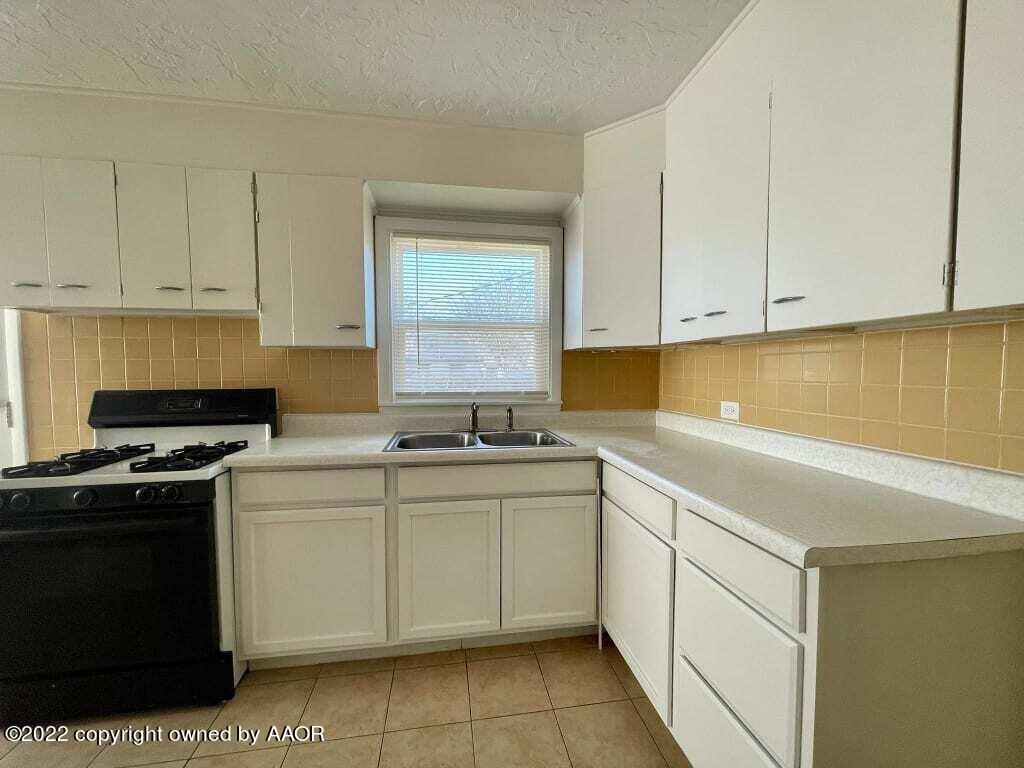 4319 Gables Street Amarillo, TX 79110 - Photo 6 of 15 a kitchen with stainless steel appliances granite countertop a sink stove and cabinets