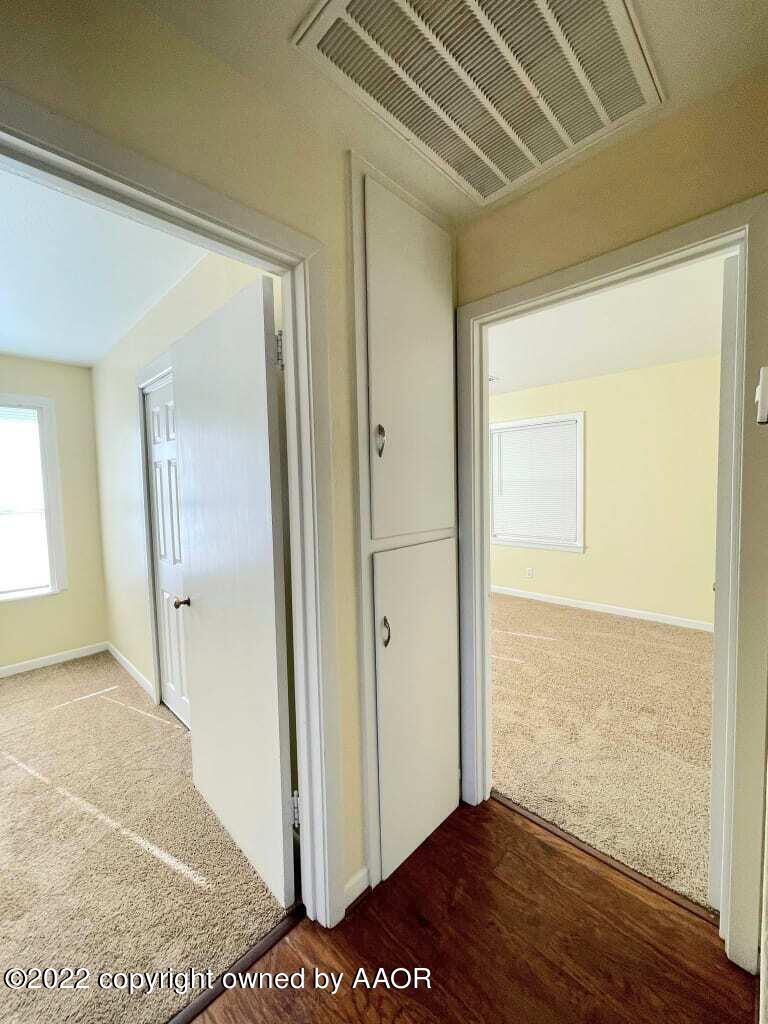4319 Gables Street Amarillo, TX 79110 - Photo 9 of 15 a view of a hallway with wooden floor and cabinet