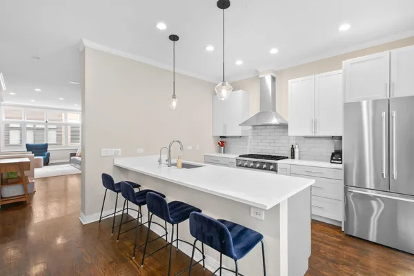 a kitchen with a dining table chairs sink and cabinets
