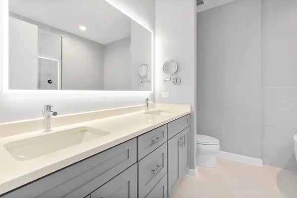 a bathroom with a sink a toilet and a large mirror