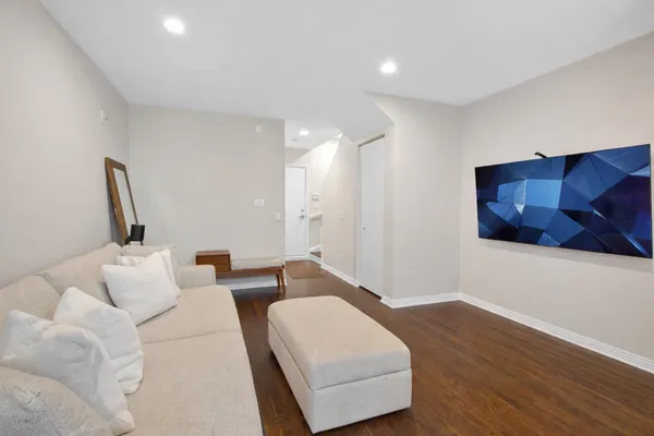 a living room with furniture and a wooden floor