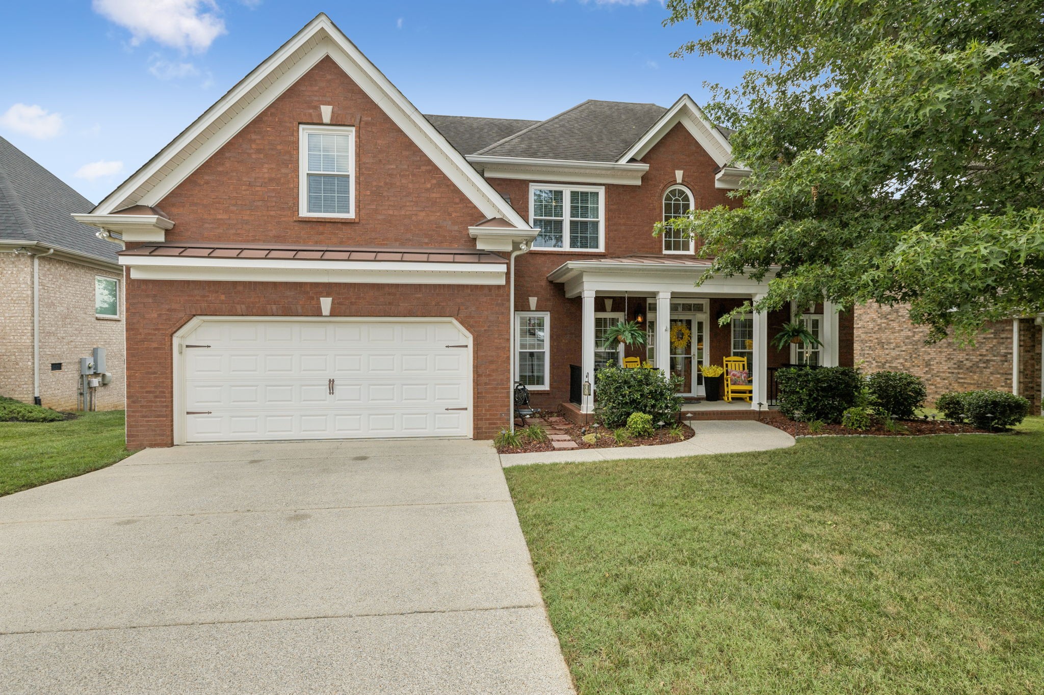 a front view of a house with yard and green space