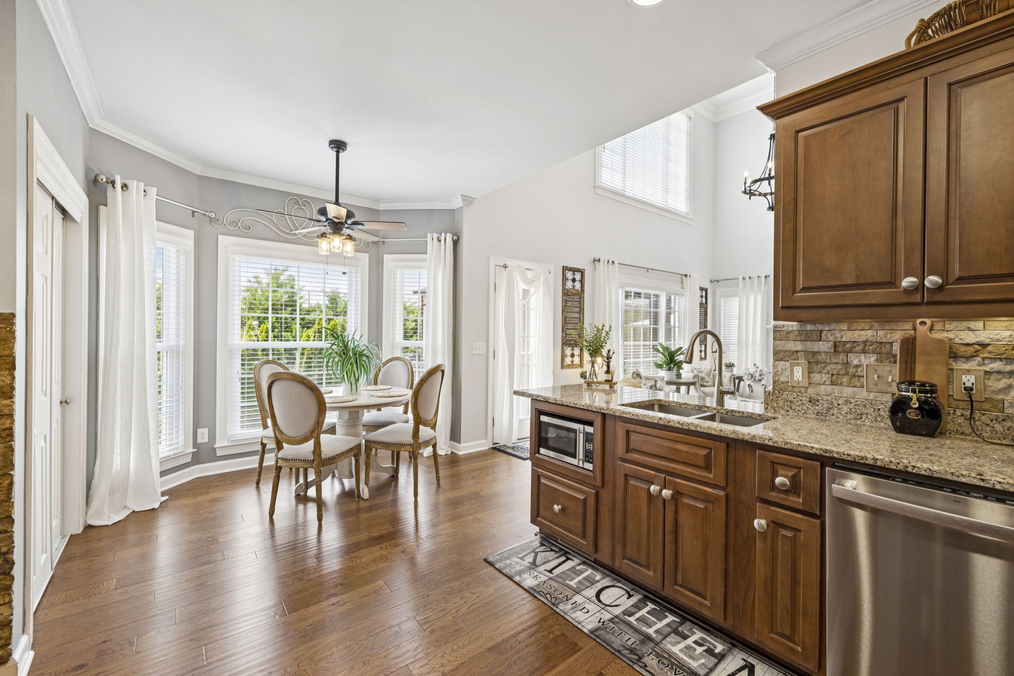 1011 Red Pepper Ridge Spring Hill, TN 37174 - Photo 30 of 76 a kitchen with stainless steel appliances granite countertop a stove top oven a sink dishwasher a dining table and chairs with wooden floor