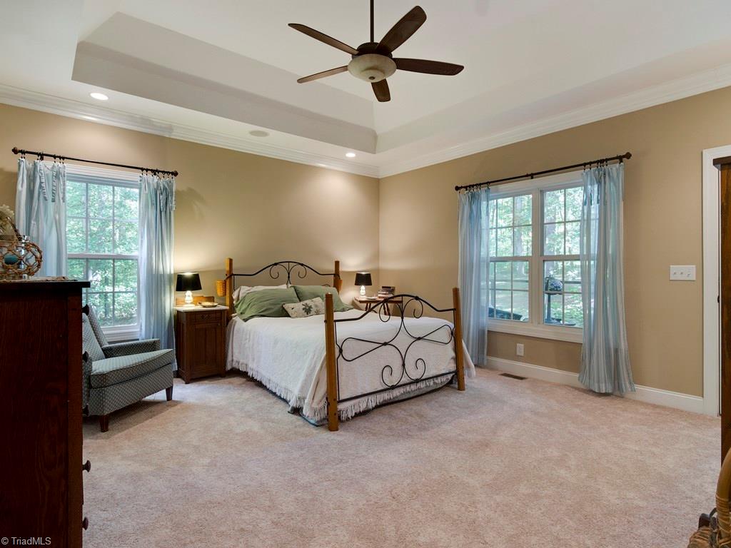 7070 Lanier Road Summerfield, NC 27358 - Photo 13 of 27 Main level Master Bedroom with new carpeting, tray ceiling & window overlooking private porch