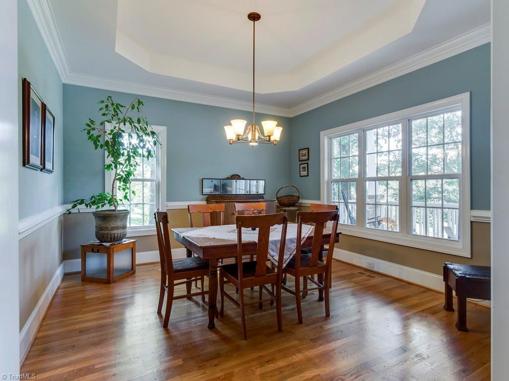 7070 Lanier Road Summerfield, NC 27358 - Photo 6 of 27 Light-filled Dining Room with chair rail, tray ceiling and crown moulding