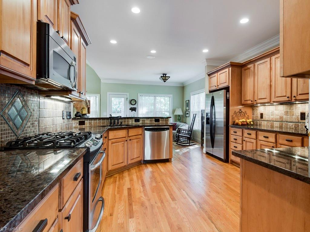 7070 Lanier Road Summerfield, NC 27358 - Photo 7 of 27 Spacious Chef's Kitchen with granite countertops, stainless steel appliances and tumbled marble backsplash. Surround sound is throughout much of the home.