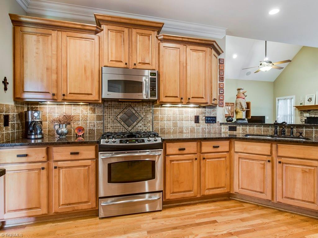 7070 Lanier Road Summerfield, NC 27358 - Photo 8 of 27 Gas range with mosaic tiled backsplash