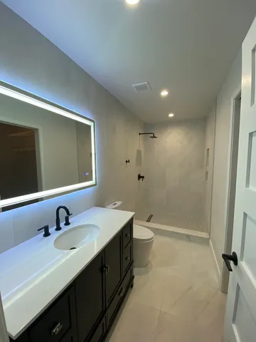 a bathroom with a double vanity sink toilet and mirror