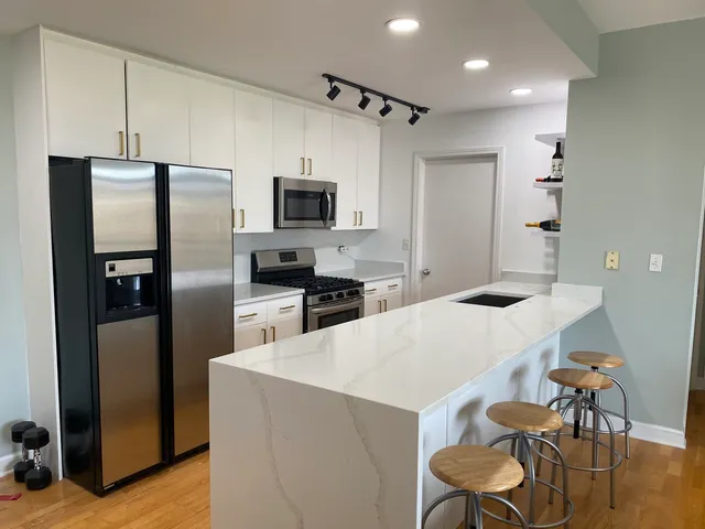 a kitchen with kitchen island a refrigerator stove and microwave