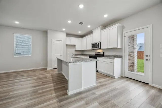 a kitchen with granite countertop white cabinets and white appliances