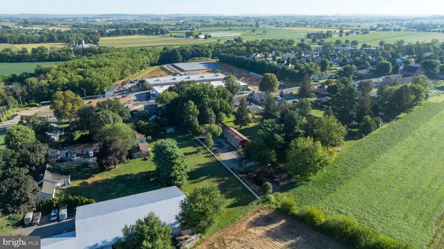 an aerial view of green landscape with trees houses and mountain view