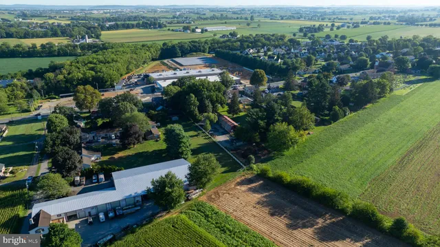 an aerial view of green landscape with trees houses and lake view